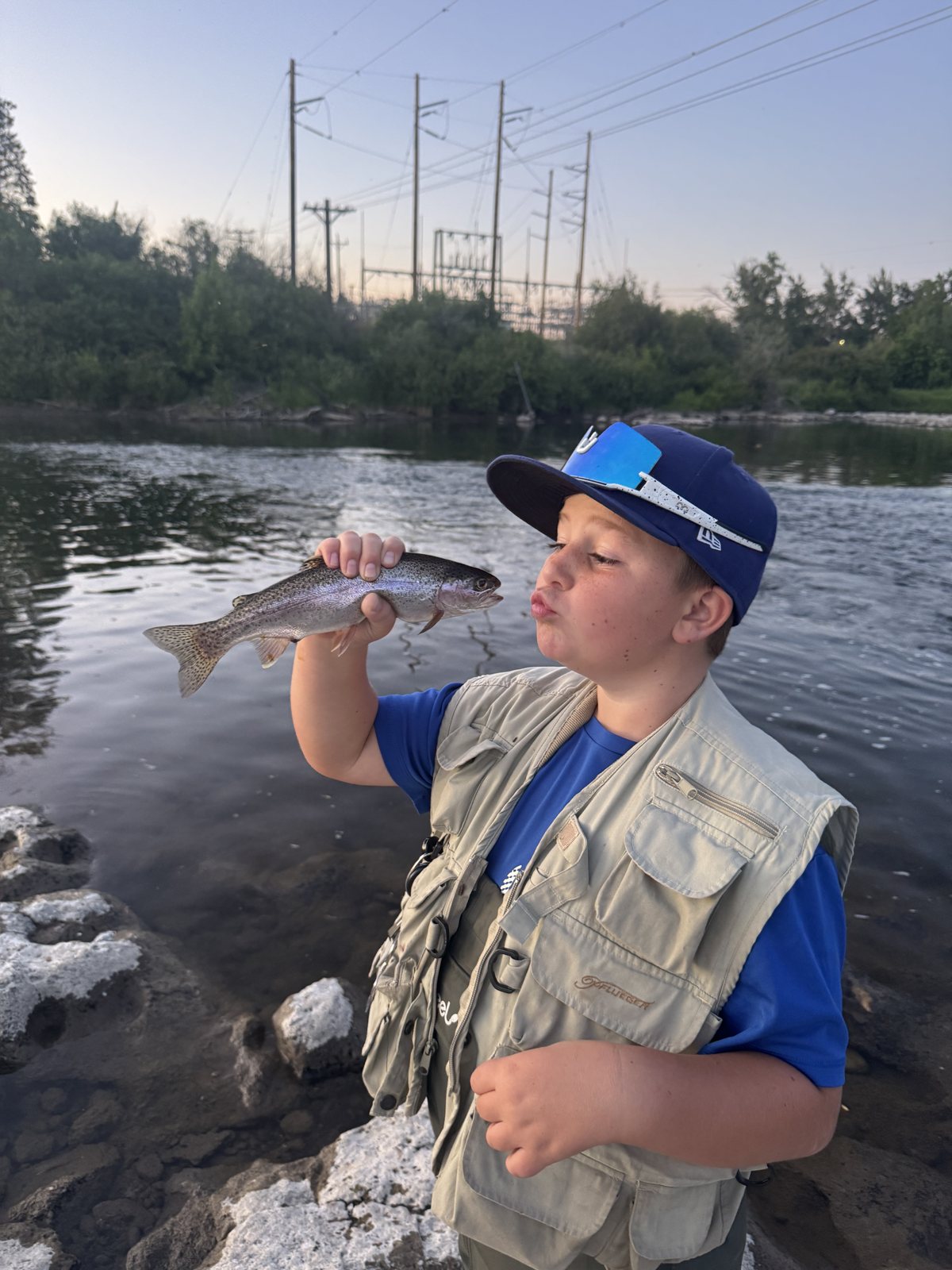 Caden kissing a rainbow trout before releasing it