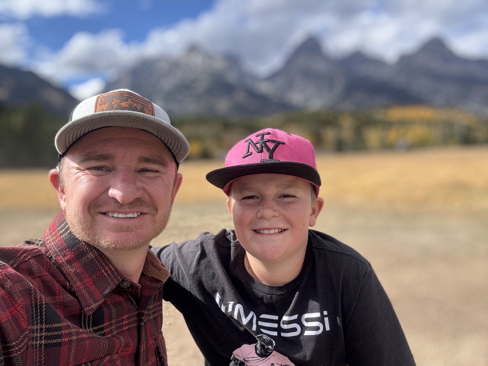 Trevor and Caden smiling in front of the Teton mountains