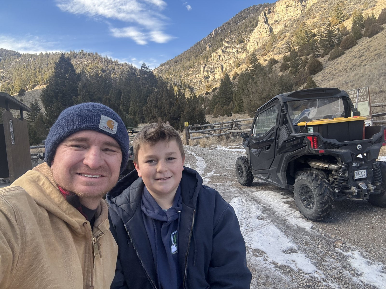 Trevor and Caden on a snowy mountain road with their side-by-side