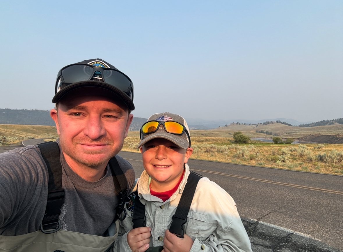 Trevor and Caden in waders on a Yellowstone valley road, ready to fish