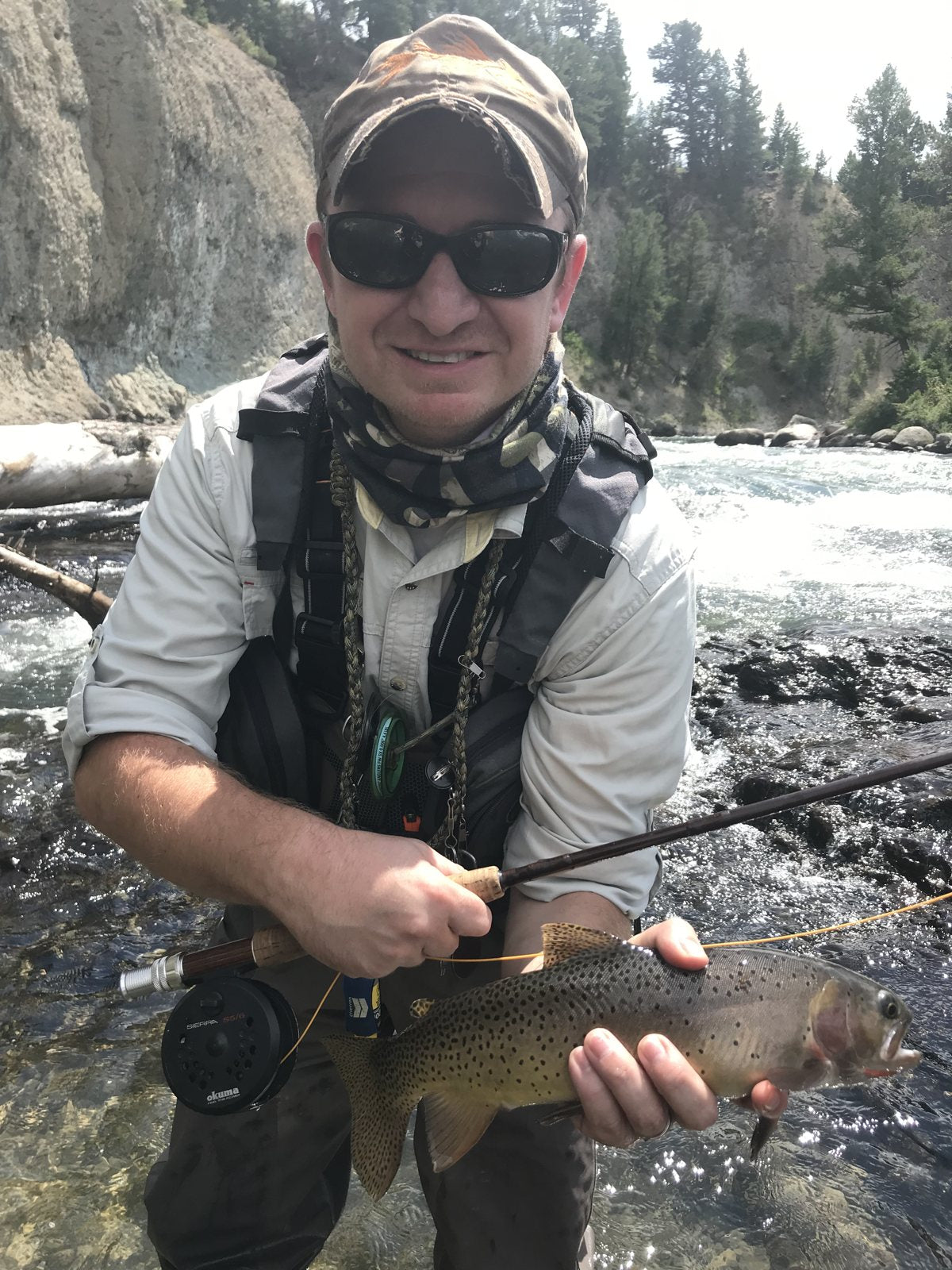 Trevor holding a brown trout in a canyon river