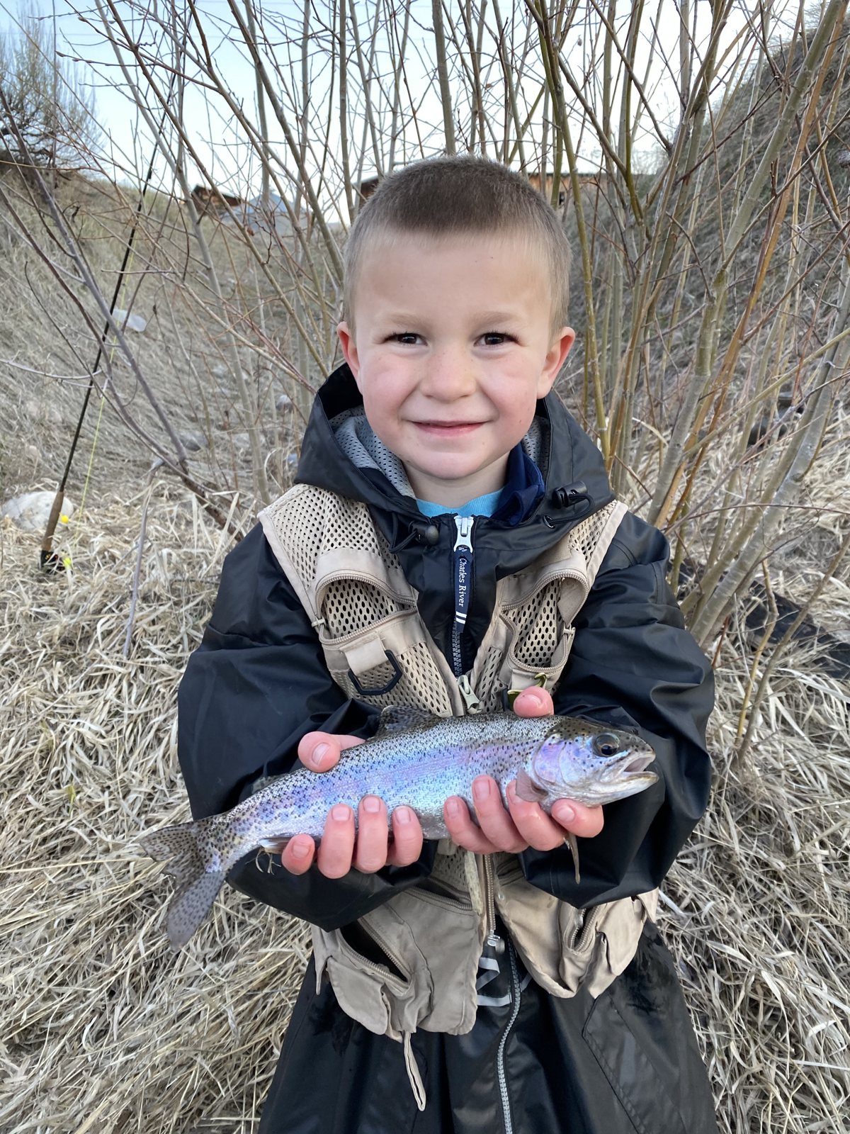 Young Caden holding a rainbow trout on the bank of the Teton River